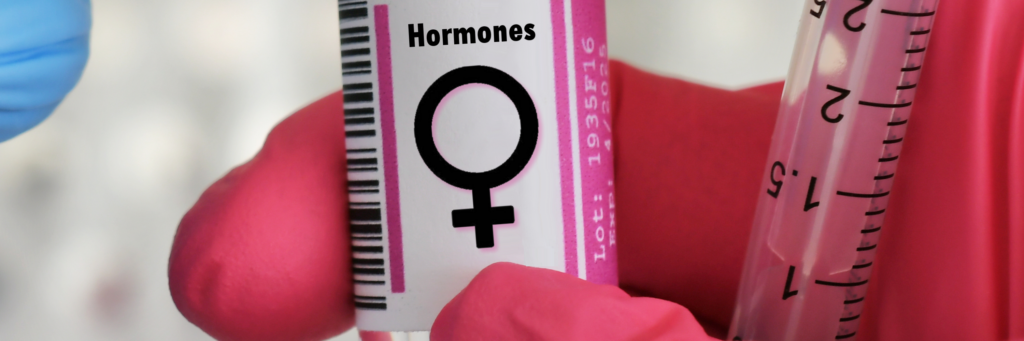 Hormone replacement therapy (HRT) vial labeled for women, held by a gloved hand with a syringe, emphasizing personalized hormonal treatment for improved health and well-being.
