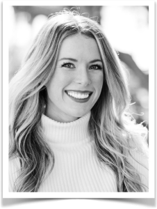 Alayna Hayes, Director of Client Care at Longitude Health, smiling in a white turtleneck sweater, emphasizing her role in fostering client relationships and promoting wellness.